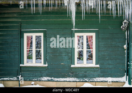 Long icicles hanging from old roof at a building in Harz Stock Photo