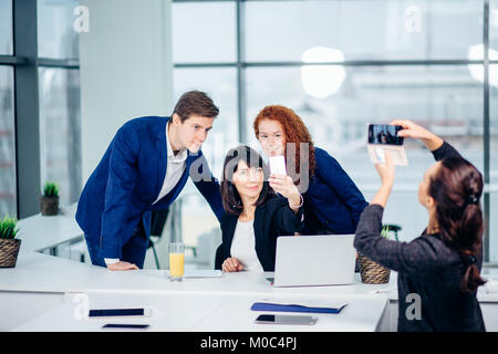 Businesswoman shooting her collegues at mobile phone camera Stock Photo