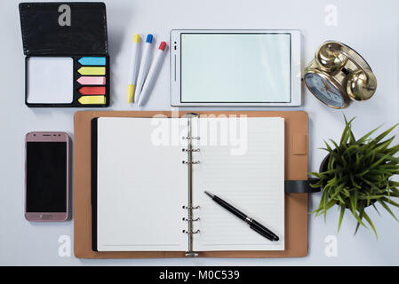 phone, digital tablet, clock, plant, memo pad and blank notebook with on white flat lay. business workspace concept Stock Photo