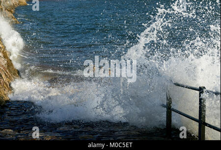 Waves crashing through seafront railings and onto the beach access ramp at high tide. Stock Photo