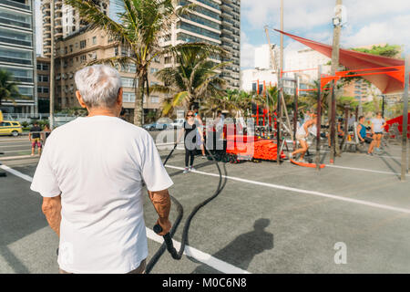 Model Released:  Older man (80-89) exercising with battling rope at public gym in Ipanema, Rio de Janeiro, Brazil Stock Photo
