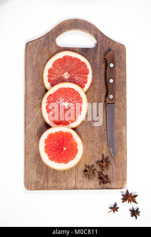 Set for mulled wine: sliced grapefruit with anise on the board on the white background. Stock Photo
