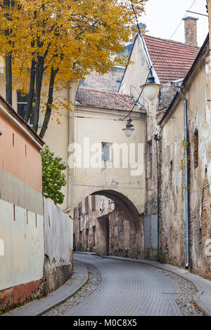 Street view, the narrow Sv Kazimiero Gatve with old dilapidated arch built over the road in the Old Town of Vilnius, capital city of Lithuania Stock Photo