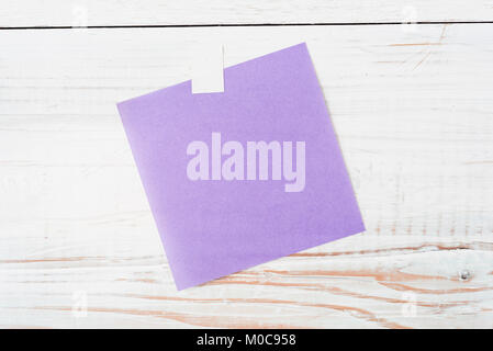 blank piece of purple note paper on rustic white wood background ready for any message Stock Photo