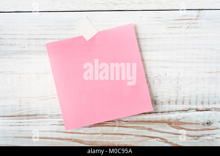 blank piece of pink note paper on rustic white wood background ready for any message Stock Photo