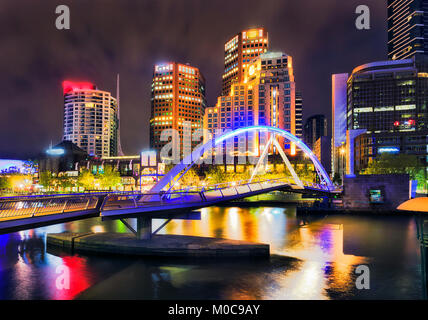 Night Melbourne city CBD landmark on south bank of Yarra river around Walker foot bridge with bright urban lights reflectign in still waters. Stock Photo