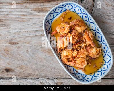 Fried Shrimp with Tamarind Sauce in white plate on wooden table with copy space Stock Photo