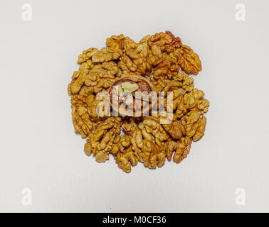 A pile of walnut kernels and cracked walnut on the top on white background Stock Photo