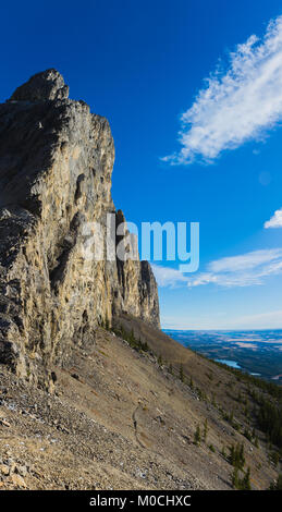 Female hiker below a massive mountain wall Stock Photo