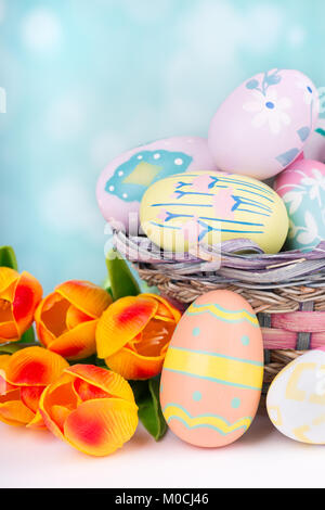 Easter eggs and tulips on a colorful background Stock Photo
