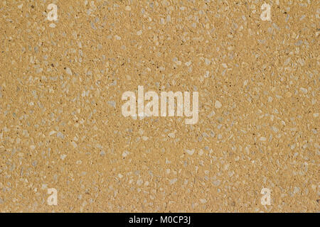 Sand colored tan stucco wall background with exposed stones on its surface Stock Photo