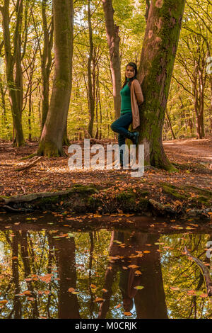 woman with colorful autumn leaves in the forest isolated Stock Photo