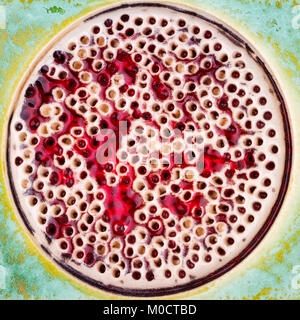 Closeup shot of glazed green ceramics texture with red dotted circle in the middle Stock Photo