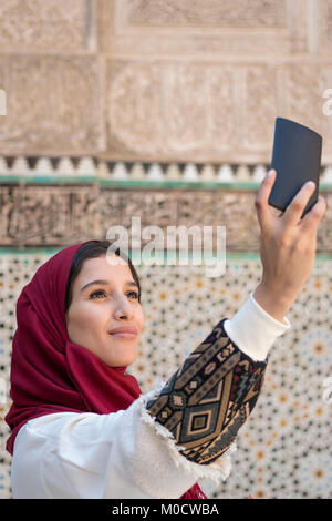 Arab woman in traditional clothing taking selfie with mobile phone Stock Photo