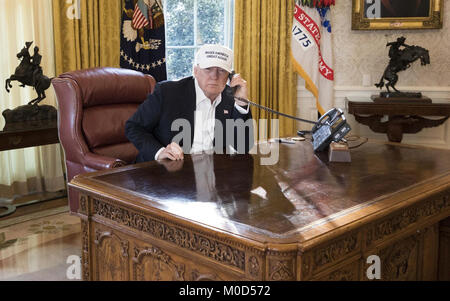 WASHINGTON, DC - JANUARY 20: President Donald J. Trump talks on the phone in the Oval Office receiving the latest updates from Capitol Hill on negotiations to end the Democrats government shutdown, Saturday, January 20, 2018, at the White House in Washington, D.C.   People:  President Donald Trump Credit: Storms Media Group/Alamy Live News Stock Photo