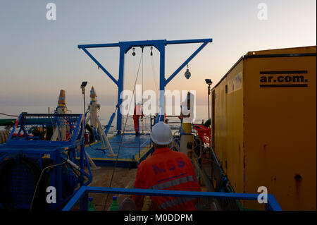 Offshore personnel deploy transponders in the Caspian Sea from the back  deck of a vessel using an A frame. Stock Photo
