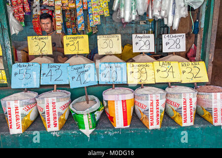 Filipino vendor offers twelve varieties of white rice at the farmer's market in Barretto, Luzon, Philippines. Stock Photo