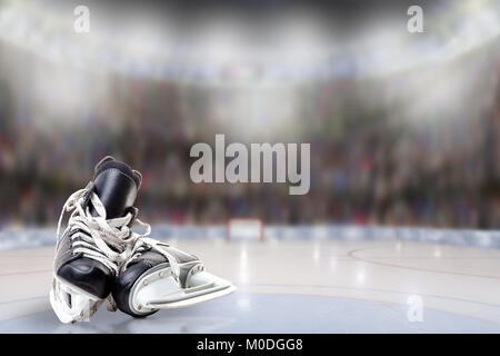 Low angle view of hockey skates on ice with deliberate shallow depth of field on brightly lit stadium background and copy space. Stock Photo