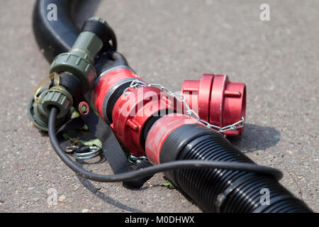 red hose coupling for water lies on ground Stock Photo