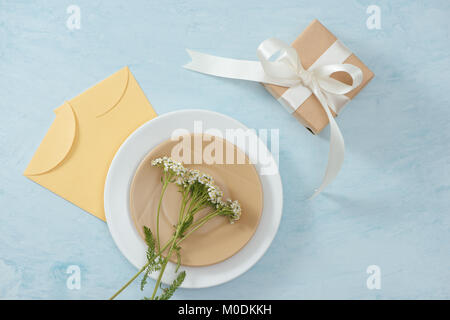 Tet Holiday Concept. Gold Envelope (Lucky money) on table with Table setting with Plate and Flowers. Stock Photo