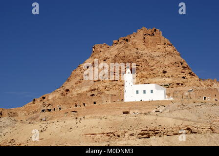 View of the abandoned hilltop Berber village of Douiret and the prominent white Nakhla Mosque, Douiret, Tataouine district, Tunisia Stock Photo
