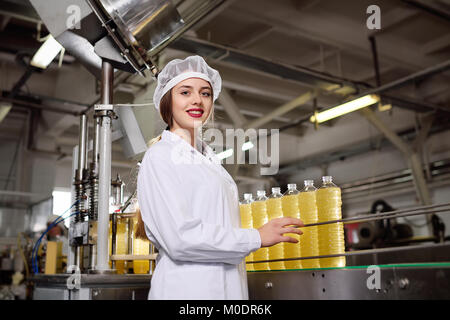 Cute young girl with a bottle of sunflower or olive oil  Stock Photo
