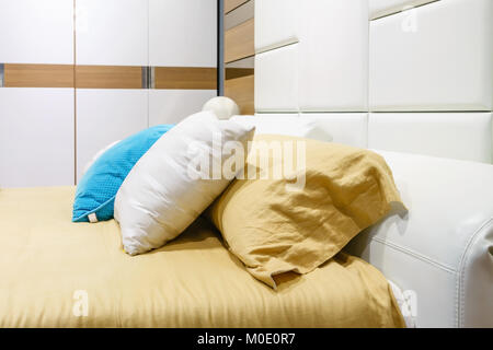 closeup of new bed comfort with decorative pillows headboard in bedroom in staging model home Stock Photo