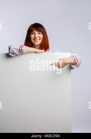 Image of chef girl in white lab coat with empty sheet for inscription Stock Photo