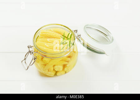 jar of sweet baby corn on white wooden background Stock Photo