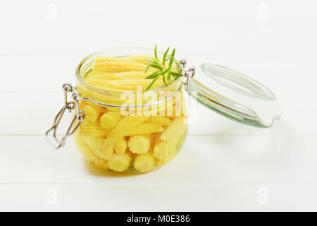 jar of sweet baby corn on white wooden background Stock Photo