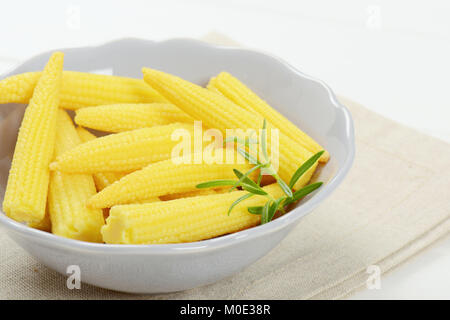 bowl of sweet baby corn on beige place mat - close up Stock Photo