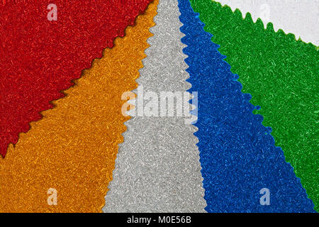 abstract wavy pattern of variety of glitter foam sheets textured texture background - multi-coloured red, yellow gold, silver, blue, green, white Stock Photo