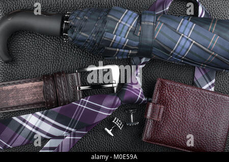 Classic luxury accessories lying on black natural leather. View from above Stock Photo