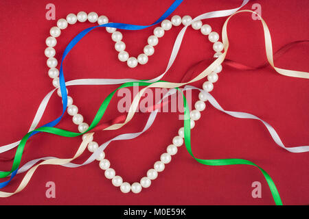 Beads in the form of heart and multi-colored satin ribbons. The concept for Valentine's Day Stock Photo