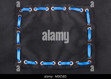 Blue ribbon is inserted in a frame made of black satin. With a place for your text Stock Photo