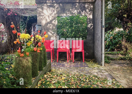 Appeltern, Netherlands, September 29, 2017: Characteristic patio with three red chairs as opportunity to sit Stock Photo