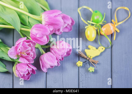 Easter composition of pink roses and colored Easter eggs and a yellow bird Stock Photo
