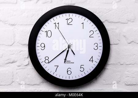 Wall clock on white brick wall, full frame, closeup Stock Photo