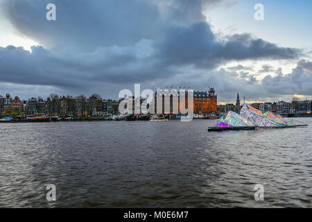 Amsterdam, Netherlands, December 16, 2017: Floating artwork of light at Oosterdok with the grandhotel Amrath Amsterdam in the background Stock Photo