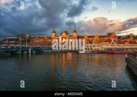 Amsterdam, Netherlands, December 16, 2017:  The Central Station of Amsterdam in the light of the setting sun Stock Photo