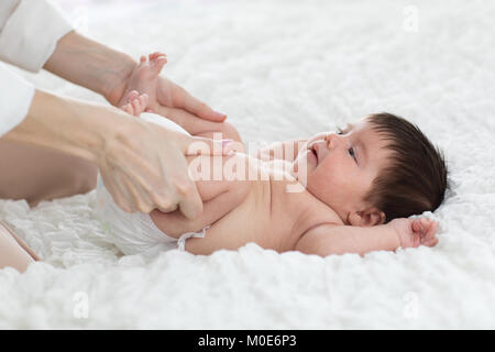 baby newborn is enjoying massage from mother Stock Photo