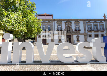 Word Invest created by big plastic letters in front of traditional architecture Stock Photo