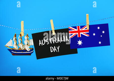 Chalkboard with the inscription: Happy day of Australia surrounded by shipwrights, a compass, a clock and an Australian flag on a blue background. 26  Stock Photo