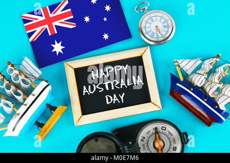 Chalkboard with the inscription: Happy day of Australia surrounded by shipwrights, a compass, a clock and an Australian flag on a blue background. 26  Stock Photo