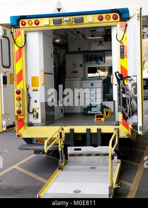 The interior of an NHS ambulance with back doors wide open waiting for a patient outside a hospital Stock Photo