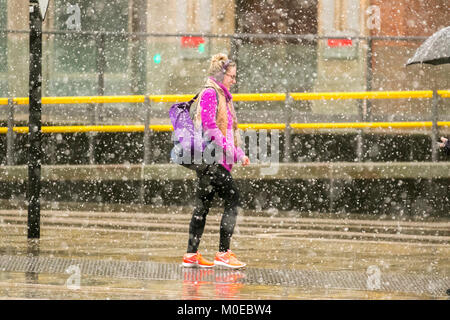 Manchester, UK Weather. 21st January, 2018.  Snowing in the city centre. A wet, cloudy, cold winters day for northern England.  UK. With blustery winds and snow showers forecast throughout the region. Credit; MediaWorldImages/AlamyLiveNews. Stock Photo