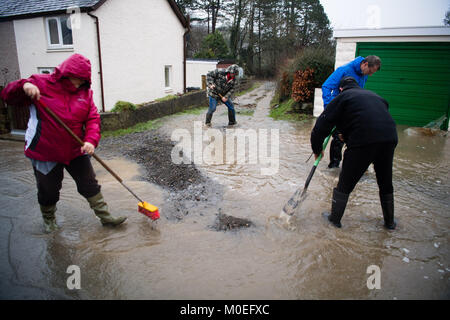 Llandre, Ceredigion Wales, Sunday 21 January 2018  UK Weather: Flood water cascade like a river down the main street in LLANDRE near Aberystwyth in Mid Wales, after hours of torrential rain caused the small steam that runs through he village to dramatically burst its banks . Local residents  made improvised sandbags and barriers to try to divert the water away from their houses. The stream overflowed high above the village just outside the parish church, sending debris down and washing away parts of the road surface    photo © Keith Morris / Alamy Live News Stock Photo