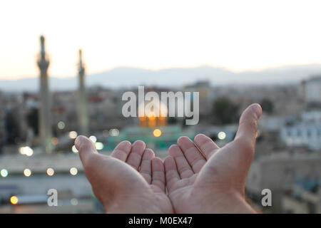 Two of open hands to pray in front of Sayeda Zeinab shrine  in Damascus, capital of Syria. Stock Photo