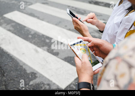 Traveler use map on mobile phone app to search for route location of place with gps on street when travel in city,Technology in lifestyle Stock Photo