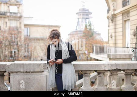 Young male model chatting with smartphone and listening to music Stock Photo